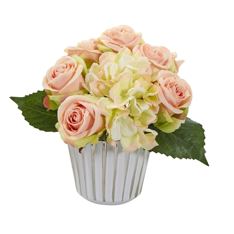 Bouquet de roses et d'hortensias artificiels dans un vase blanc et argenté